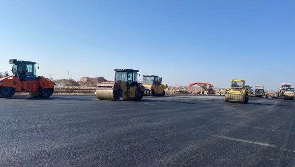 近日，在球王会平台兰州新区城市矿产与表面处理产业园区（二期）周边基础设施项目—园区西路南延段（纬五十路至纬二十八路）项目现场，随着一辆辆运料车平稳驶入，摊铺机将滚烫的沥青混合料均匀铺开，标志着项
